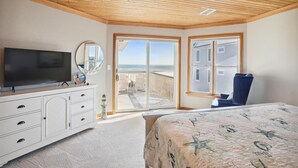 A bedroom with a TV, dresser, and a bed with a quilt. - OH-10 "Nirvana" Saturday-Saturday   Private Pool!  Oceanfront (Corolla)