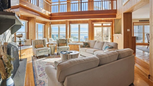 A spacious living room with high ceilings, large windows, and a balcony. - OH-10 "Nirvana" Saturday-Saturday   Private Pool!  Oceanfront (Corolla)