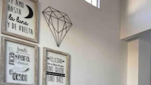 Un comedor con mantel a cuadros, una planta en maceta y frases inspiradoras enmarcadas en la pared.