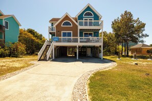 A two-story house with a balcony and a covered entryway.