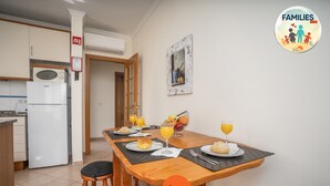 Comedor con mesa de madera lista para el desayuno, con croissants y zumo de naranja.