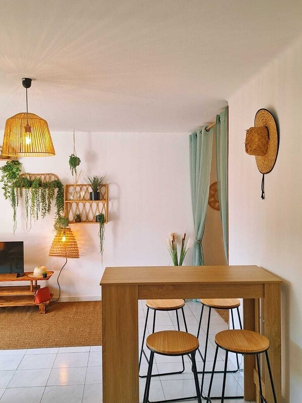 Cozy retreat with a dining table, TV, and lush greenery.