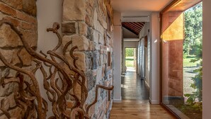 A modern interior with a stone wall, wooden floor, and a view of a garden. - Lovely home in Rocca di Papa (Rocca di Papa)