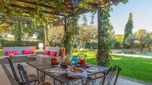 An outdoor patio with a table set for dining, surrounded by chairs and a sofa. - Lovely home in Rocca di Papa (Rocca di Papa)
