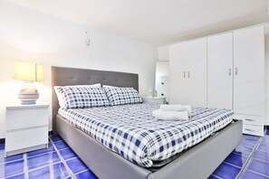 Une chambre à coucher avec un lit, une table de chevet, une lampe et une armoire.