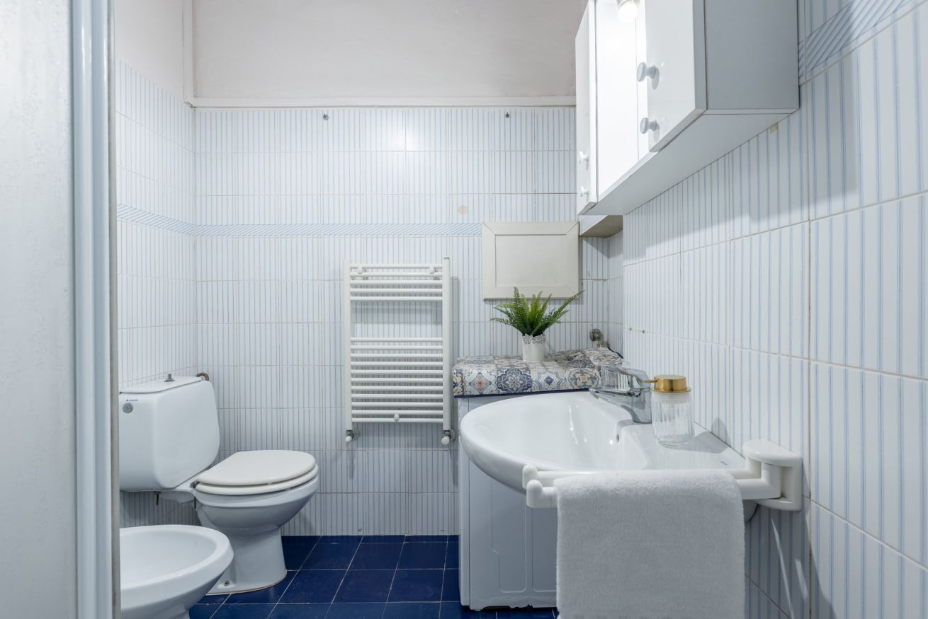 Een badkamer met toilet, bidet en wastafel.