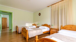 A room with two wooden beds, a green door, and a wooden floor. - Casa Iris 2 (Falcade)