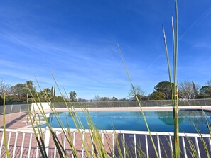 Relax by the pool surrounded by lush greenery and a serene atmosphere.