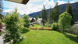 A view of a mountainous landscape with a building surrounded by trees and a grassy area. - Villa Licia bilo (Falcade)