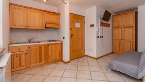 A compact kitchen with wooden cabinets, a built-in stove, and a sink.