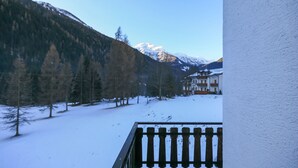 A snowy mountain landscape with a building in the background. - Casa Zulian (Falcade)