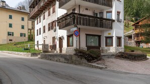 Ein mehrstöckiges Gebäude mit Balkonen, einem Verbotsschild und einem Hinweis auf eine nahegelegene Schule.