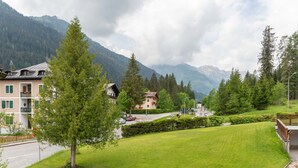 A residential area with houses, a well-maintained lawn, and mountains in the background. - Casa Morel (Falcade)