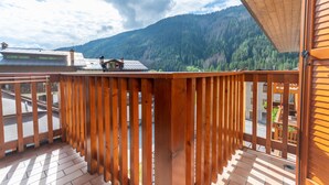 Ein Holzbalkon mit Blick auf einen Berg und eine Straße.