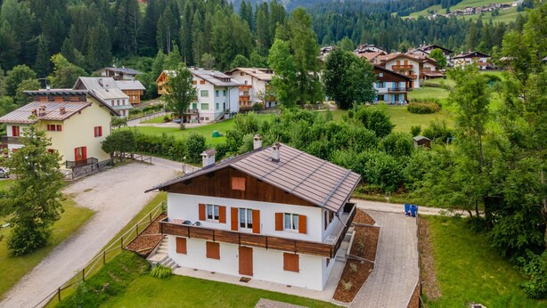 A residential area with houses surrounded by greenery and mountains in the background. - Villa Elisena (Falcade)