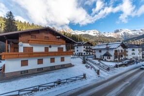 A snow-covered village with wooden buildings and a road.