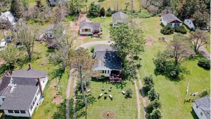An aerial view of a residential area with multiple houses, lawns, and trees. - Pine Cottages (Stanhope)