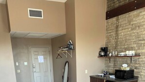 A modern kitchen with a dishwasher, microwave, and a hanging rack above the counter. - The Avonlea Inn (Stratford)