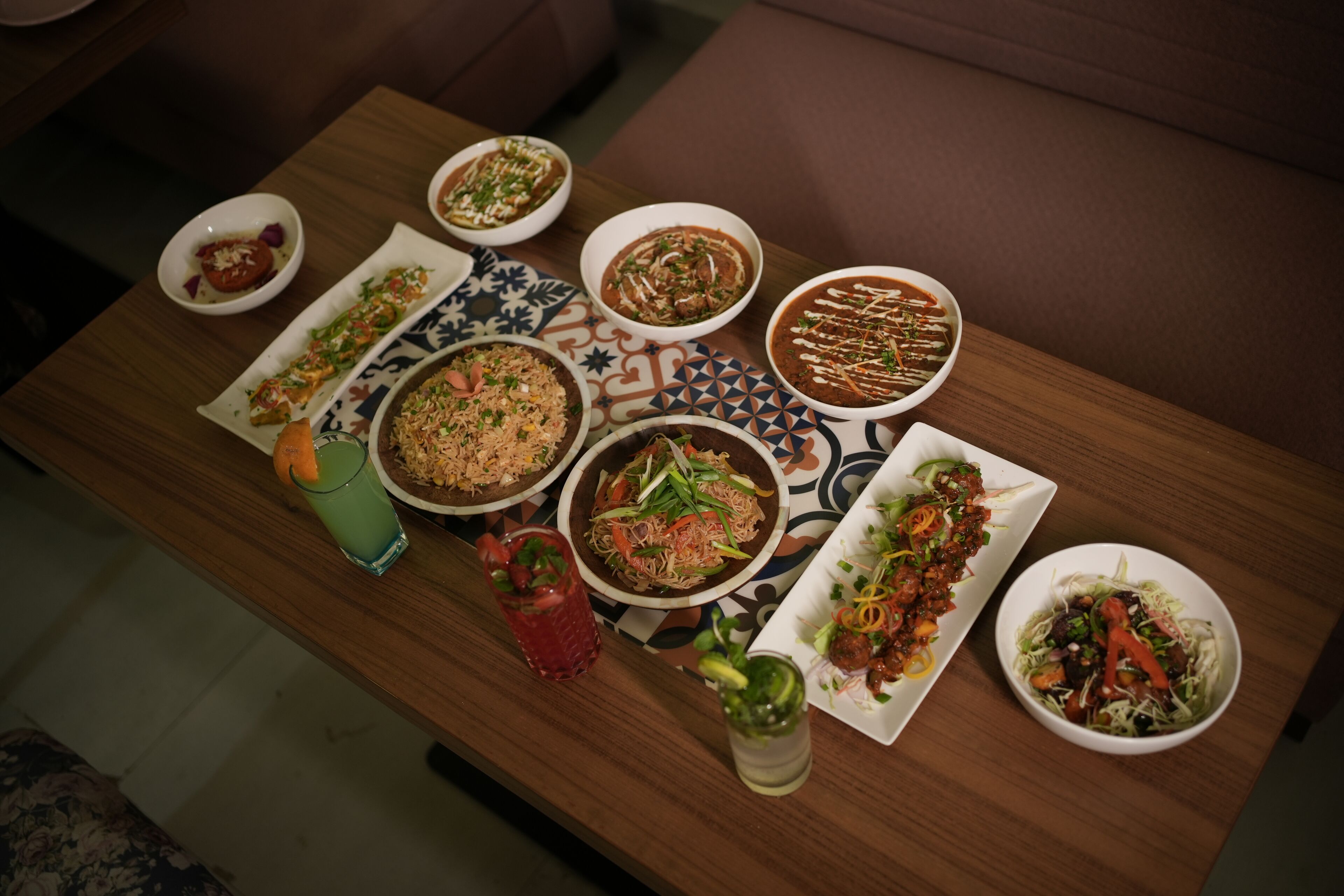 A dining table with various dishes and drinks.