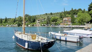 A marina with several boats docked, a clear sky, and buildings in the background.