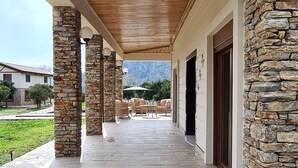 A covered outdoor area with stone pillars, a wooden ceiling, and a stone wall. - Sea and lake, sun and sand, history and geography we offer you with family warm. (Köyceğiz)