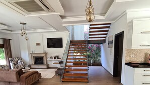 A spacious living room with a wooden staircase, a fireplace, and a modern kitchen. - Sea and lake, sun and sand, history and geography we offer you with family warm. (Köyceğiz)