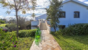 Uma trilha que leva a uma casa moderna com uma escadaria.