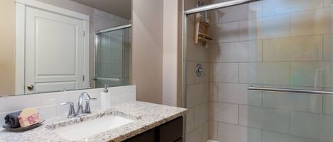 Chuveiro, toalhas de banho, sabonete, shampoo