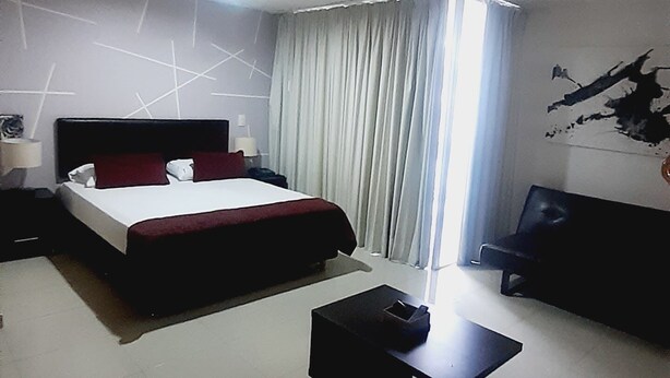 A modern hotel room with a large bed, a desk, and a chair. - Aparta Estudio Loft (Bucaramanga)