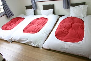 A double bed with a red and white bedspread, a wooden floor, and a window with curtains. - RETRO (Fujikawaguchiko)