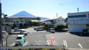 A street view with a mountain in the background, vehicles, and buildings. - RETRO (Fujikawaguchiko)