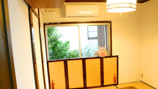 A traditional Japanese room with tatami flooring, a low wooden table, and a sliding door with a view of greenery outside. - RETRO (Fujikawaguchiko)