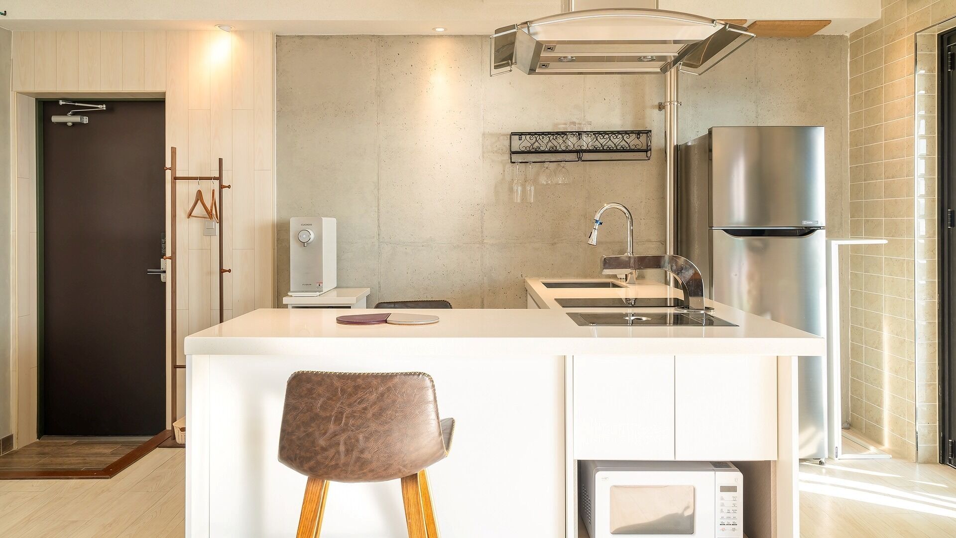 A modern kitchen with a central island, stainless steel appliances, and a built-in microwave.