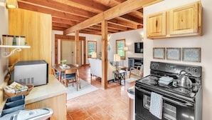 A kitchen with a stove, microwave, and wooden cabinets. - Pet-Friendly Cabin in Marietta w/ Porch Swings (Cleveland)