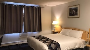 Cozy retreat with a single bed, bedside table, and window with curtains.