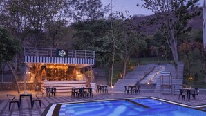A poolside area with a bar and outdoor seating. - Essentia Udaipur Luxury Resort & Spa (Udaipur)