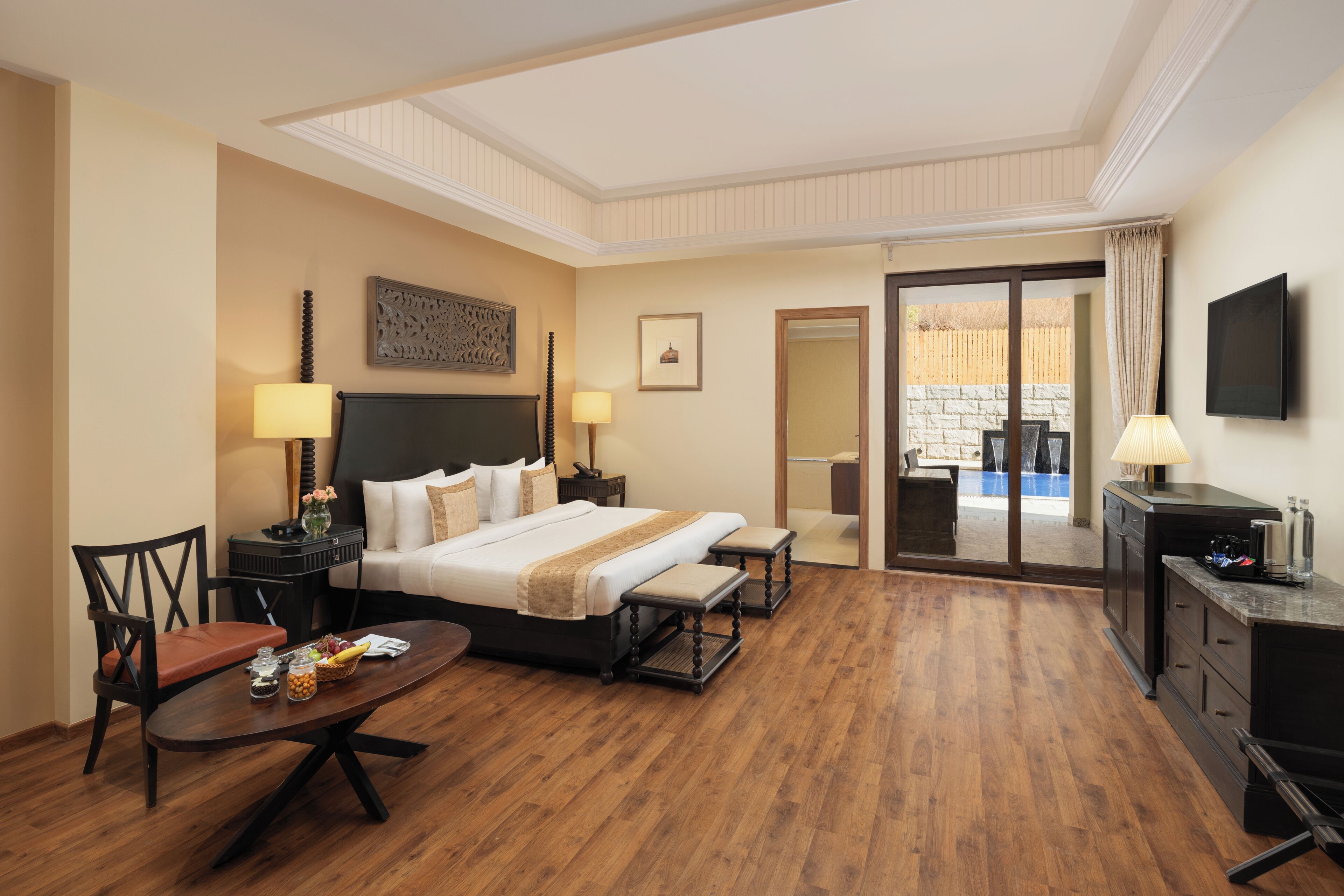 A hotel room with a large bed, bedside tables, a desk, and a view of the outside.