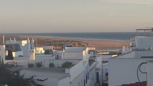 A coastal residential area with white buildings, a beach in the distance, and a clear sky. - Casa El Encanto, overlooking the sea. (Conil de la Fra.)