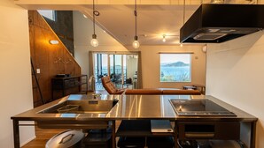 A modern kitchen with a large island, stainless steel appliances, and a view of the sea. - The View minamiboso (Minamiboso)