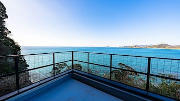Een balkon met vrij uitzicht op zee en het verre land.