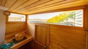A wooden sauna room with a view of a bridge and trees. - The View minamiboso (Minamiboso)
