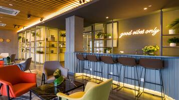 Uma área de estar moderna com assentos, um bar e um letreiro de neon.