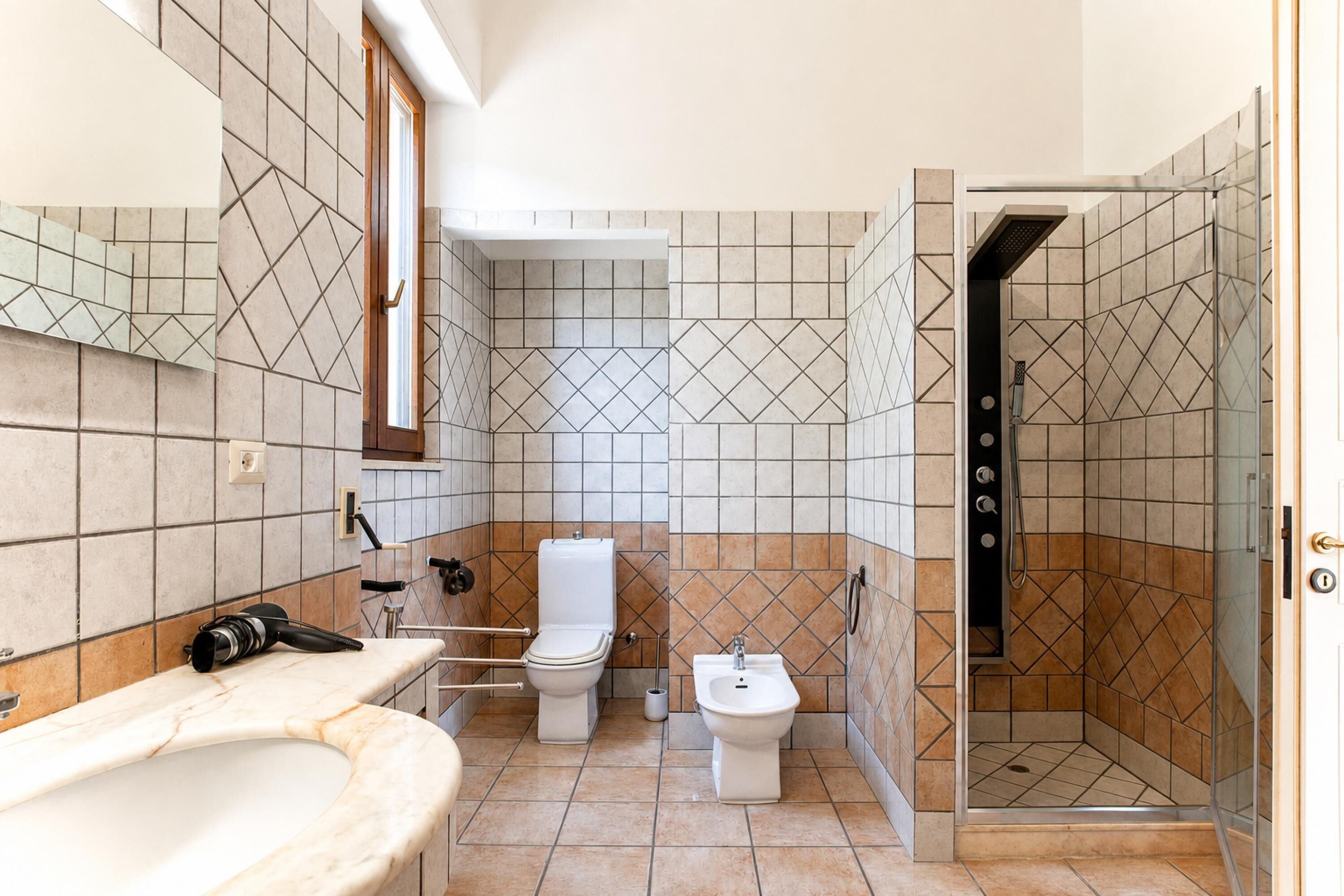 Un baño con inodoro, bidé y ducha.