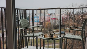 A balcony with two green chairs and a small table with cups and a plant. - Menta Panorama Apartment Widok na Oper Nova Brd (Bydgoszcz)