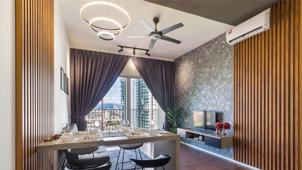 Un espace de repas moderne avec une table dressée pour quatre personnes, un ventilateur de plafond et un grand téléviseur fixé à un mur en bois.