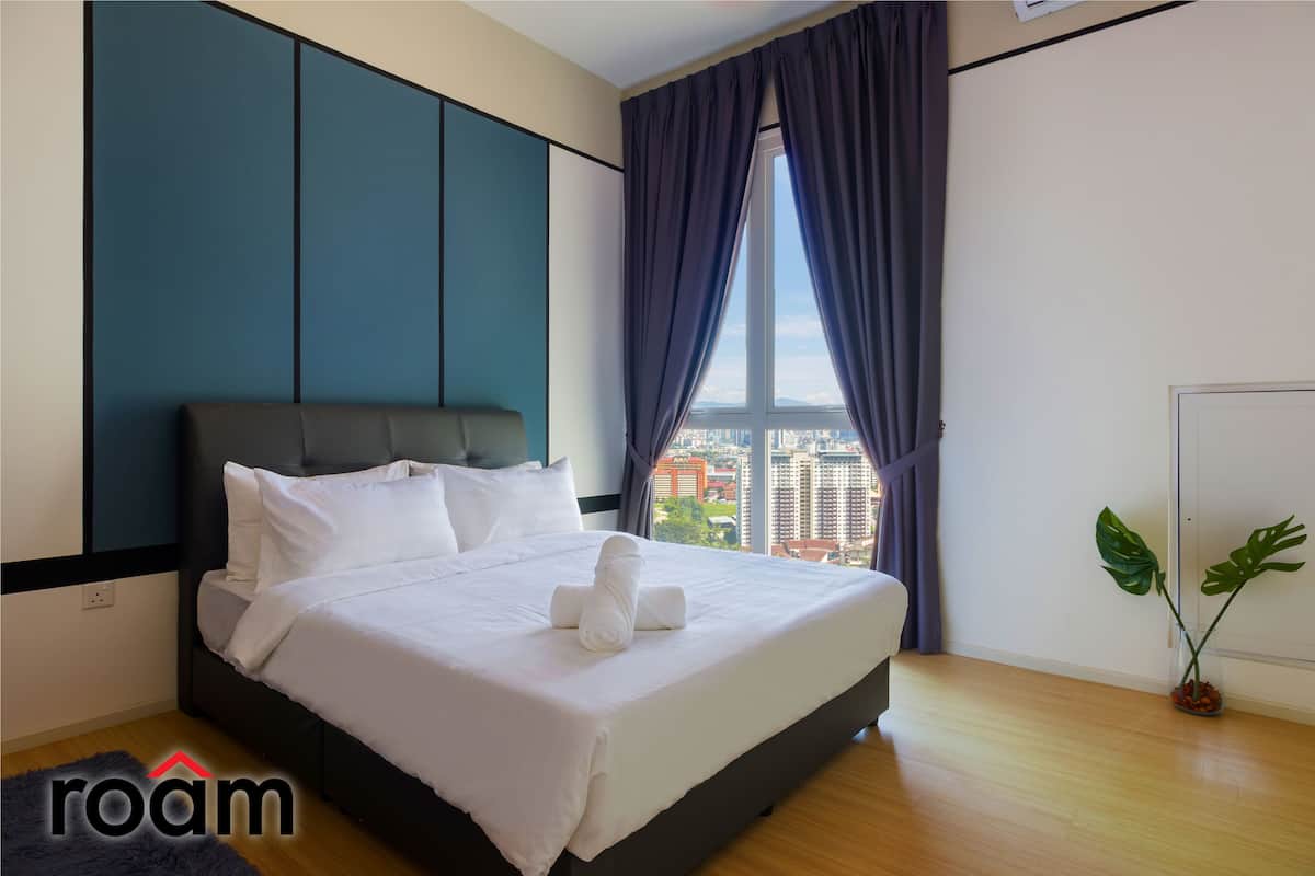 Ein modernes Hotelzimmer mit einem großen Bett, Blick auf die Stadt und einer Zimmerpflanze.