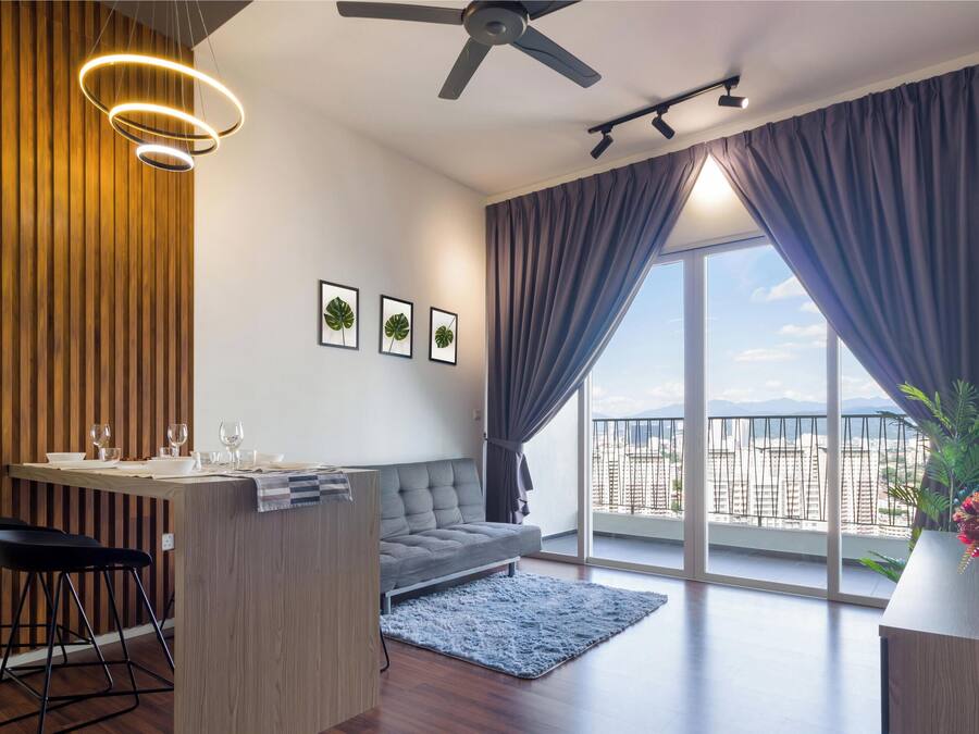 Una sala moderna con sofá, mesa de comedor y sillas, un balcón con vistas y un ventilador de techo.