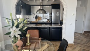 A modern kitchen with dark cabinets, a stainless steel refrigerator, and a granite countertop. - AP393 LOS ALMENDROS (Nerja)