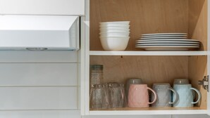 A kitchen with white cabinets, a stove, and a microwave.