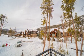 Un paysage enneigé avec des chalets en bois et une voiture garée dans l’allée.